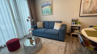 a living room with a blue couch and a table at Cozy apartment with terrace, SJ Cosmopolitan Tower #402 in San José