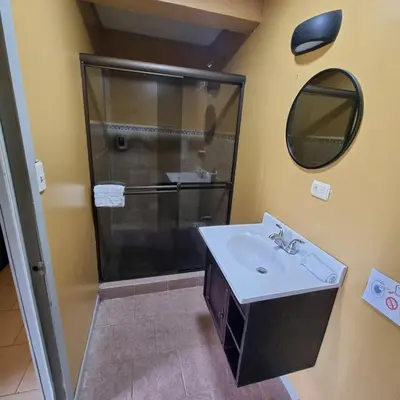 a bathroom with a sink and a shower with a mirror at Hotel Ticozuma in Montezuma