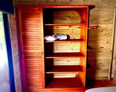 a wooden cabinet with shelves in a room at Ocean Melody 3 in Uvita