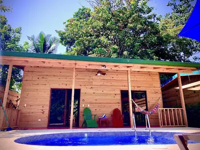 a wooden house with a pool in front of it at Ocean Melody 3 in Uvita