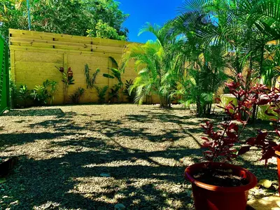 a yard with a fence and a plant in a pot at Ocean Melody 3 in Uvita
