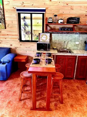 a kitchen with a wooden table with wine glasses on it at Ocean Melody 3 in Uvita
