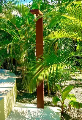 a red pole in front of some palm trees at Ocean Melody 3 in Uvita