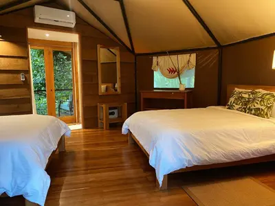 a bedroom with two beds and a television in it at Hotel Arenal Glamping in Fortuna