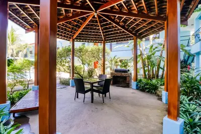 a patio with a table and chairs under a pergola at Marina Loft 221 in Coco