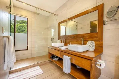 a bathroom with two sinks and a mirror at Casa Coralis - Stunning modern 3 BR, 3-half bath home in Playa Potrero in Potrero