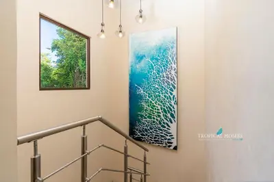 a painting on a wall next to a staircase at Casa Coralis - Stunning modern 3 BR, 3-half bath home in Playa Potrero in Potrero