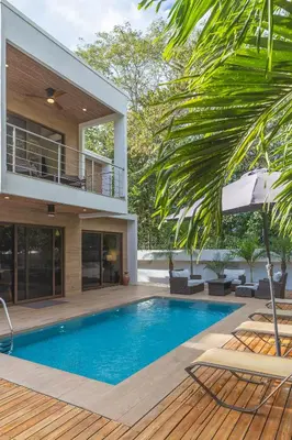 a villa with a swimming pool and a house at Casa Coralis - Stunning modern 3 BR, 3-half bath home in Playa Potrero in Potrero