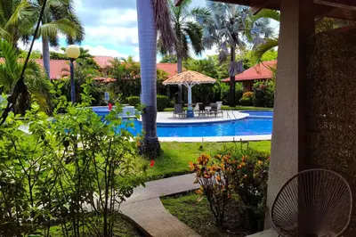a resort yard with a swimming pool and palm trees at Villaggio Claudia 29B in Potrero
