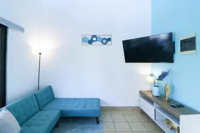 a living room with a blue couch and a flat screen tv at Villaggio Claudia 29B in Potrero