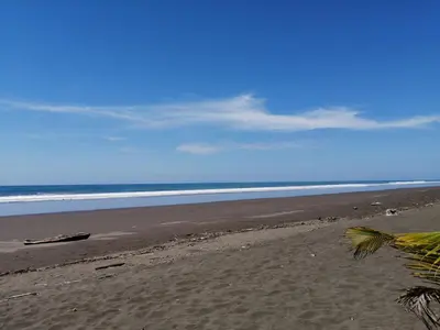 an empty beach with the ocean in the background at A 2 minutes de la PLAGE chambre du bonheur CABALLO DEL MAR in Parrita