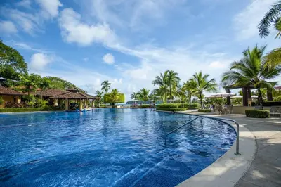 a swimming pool at a resort with palm trees at Del Mar 5F 3 bdr Garden View in Los Suenos in Herradura