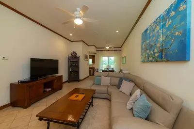 a living room with a couch and a flat screen tv at Veranda 8H 3 bdr Garden View in Los Suenos in Herradura