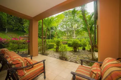 a porch with two chairs and a view of a garden at Veranda 8H 3 bdr Garden View in Los Suenos in Herradura