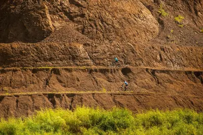 two people riding a bike on a dirt hill at Veranda 8H 3 bdr Garden View in Los Suenos in Herradura