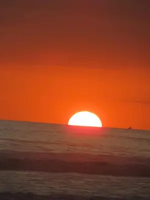 a sunset over the ocean with the sun setting at Maison du Bonheur CABALLO DEL MAR sur la plage avec bassin de rafraichissement in Parrita