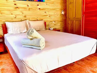 a bedroom with a white bed with towels on it at Ocean Melody 4 in Uvita