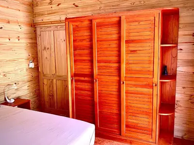 a bedroom with a bed and a wooden wall at Ocean Melody 4 in Uvita