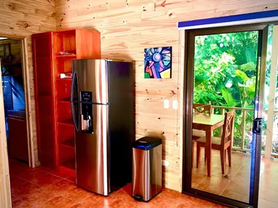 a kitchen with a stainless steel refrigerator and a table at Ocean Melody 4 in Uvita