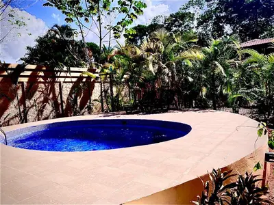 a large swimming pool in a yard with trees at Ocean Melody 4 in Uvita