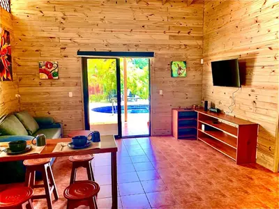 a living room with a table and a television in a cabin at Ocean Melody 4 in Uvita