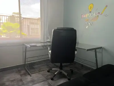 an office with a desk and a chair and a table at Casa Laureles in Guápiles