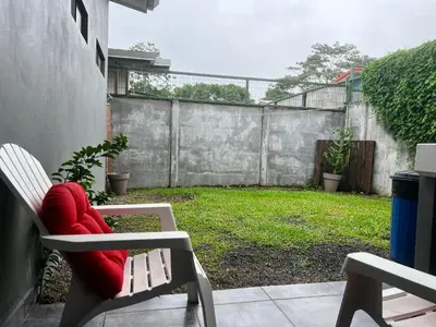 a patio with a red chair and a fence at Casa Laureles in Guápiles