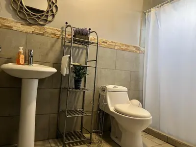 a bathroom with a toilet and a sink at Casa Laureles in Guápiles