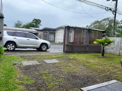 a white car parked in a driveway with a gate at Casa Laureles in Guápiles