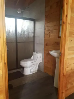 a bathroom with a toilet and a sink at Cabaña Tio King in Uvita