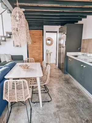 a kitchen and dining room with a white table and chairs at Little Escape in Santa Teresa Beach