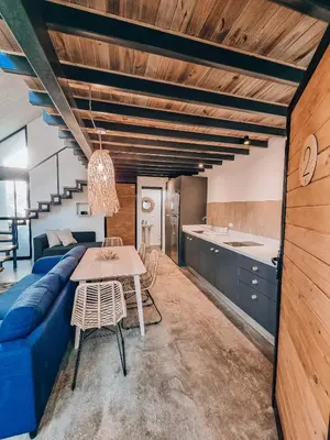 a living room with a blue couch and a table at Little Escape in Santa Teresa Beach