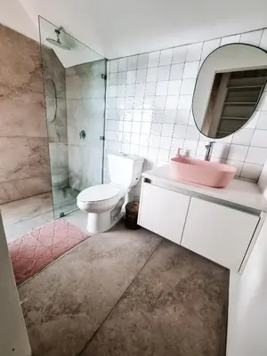 a bathroom with a toilet and a sink and a mirror at Little Escape in Santa Teresa Beach