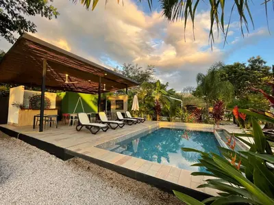 a swimming pool with chairs and a house at Pyramid Tamarindo Luxury Hotel in Tamarindo