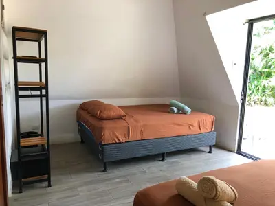 a small bedroom with a bed and a book shelf at Pyramid Tamarindo Luxury Hotel in Tamarindo
