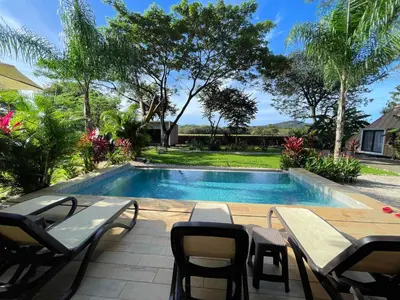 a swimming pool with a table and chairs next to it at Pyramid Tamarindo Luxury Hotel in Tamarindo