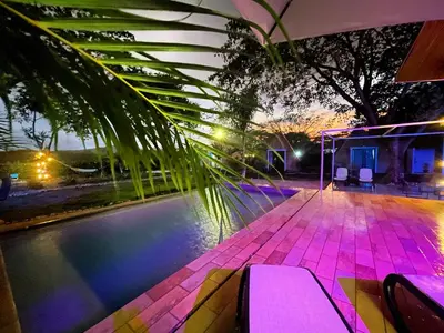 a swimming pool at night with purple lights at Pyramid Tamarindo Luxury Hotel in Tamarindo