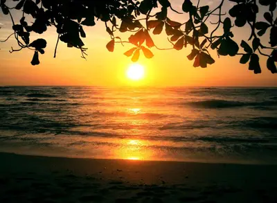 a sunset on the beach with the ocean at Manala Hotel in Santa Teresa Beach