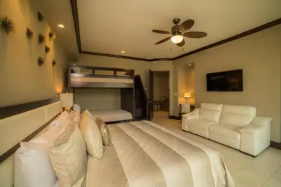 a bedroom with a bed and a bunk bed at Vista Bahia 3D 3 bdr Ocean View in Los Suenos in Herradura