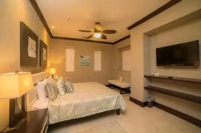 a bedroom with a bed and a flat screen tv at Vista Bahia 3D 3 bdr Ocean View in Los Suenos in Herradura