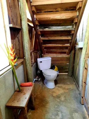 a bathroom with a toilet in a wooden structure at La Muñequita Lodge 2 - culture & nature experience in Palmar Sur