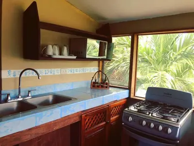 a kitchen with a stove and a sink and a window at Beautiful Second Story Apartment 202 Next to Playa Flamingo in Playa Flamingo