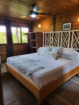 a bedroom with a large bed in a cabin at Jaco-Carara 3 bdrm surrounded by rainforest with private pool in Carara