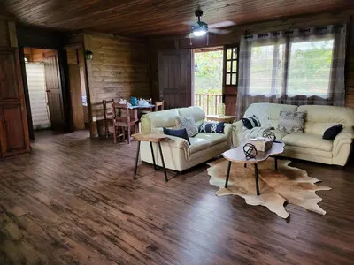a living room with two couches and a table at Jaco-Carara 3 bdrm surrounded by rainforest with private pool in Carara