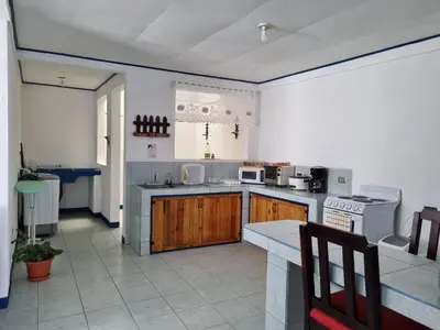 a large kitchen with wooden cabinets and a stove at Entire Cozy apartment for you, 5 min SJO Airport in Alajuela City