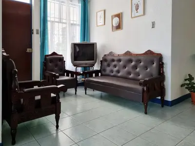 a living room with two chairs and a couch and a tv at Entire Cozy apartment for you, 5 min SJO Airport in Alajuela City