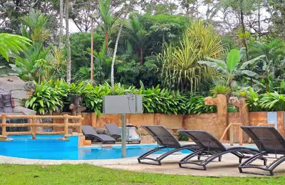 a group of chairs sitting next to a pool at Hotel Rio Celeste to Know in Rio Celeste
