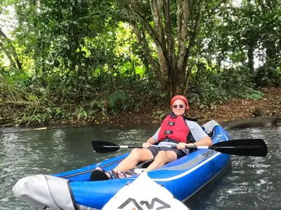 a woman is sitting in a kayak on a river at Hotel Rio Celeste to Know in Rio Celeste