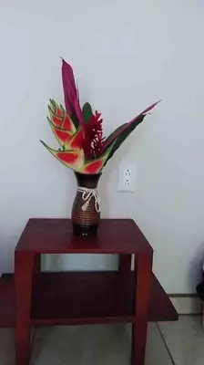 a vase with flowers in it sitting on a table at Hospedaje Rio Celeste Katira, Habitación privada in San Rafael
