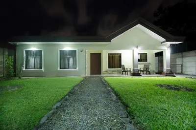 a small house with a green lawn in front of it at Elegant Villa in La Fortuna with spacious backyard plus very private pool & parking in Fortuna
